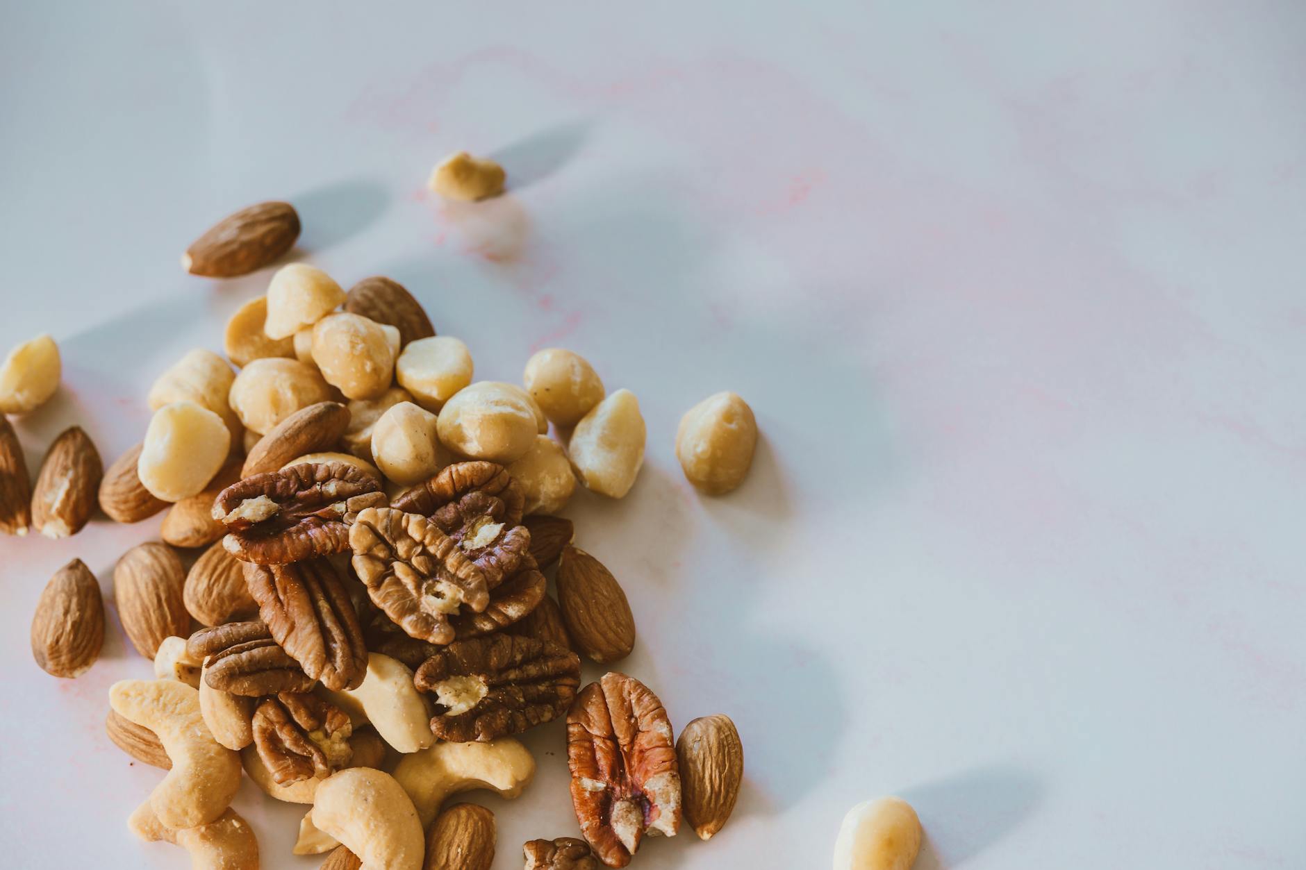 close up shot of assorted nuts on a white surface